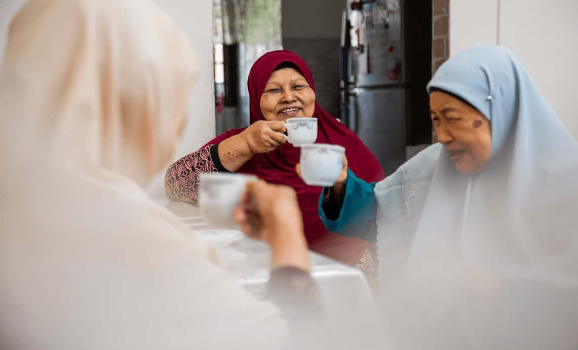 A group of elderly ladies sipping on some tea